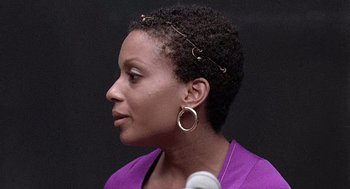 Movie still from “Taking Off” (1971), directed by Milos Forman – A person wearing a purple shirt; Close Up shot, Over the shoulder angle