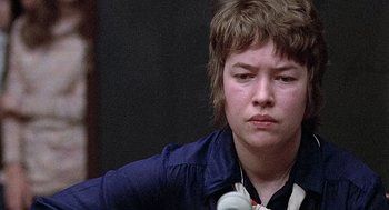 Movie still from “Taking Off” (1971), directed by Milos Forman – A young person with headphones and a blue jacket; Close Up shot, Over the shoulder angle