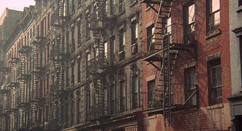 Movie still from “Taking Off” (1971), directed by Milos Forman – Fire escapes on the side of an apartment building in new york city; Extreme Wide shot, Low angle