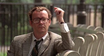 Movie still from “Taking Off” (1971), directed by Milos Forman – A man in a suit and tie holding his arm up; Close Up shot, Low angle