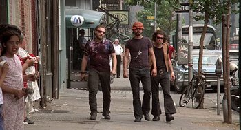 Movie still from “Taking Off” (1971), directed by Milos Forman – A group of men walking down a street; Wide shot, Low angle