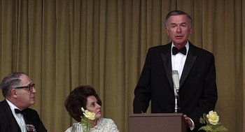 Movie still from “Taking Off” (1971), directed by Milos Forman – An older man in a tuxedo standing next to a woman; Medium shot, Low angle