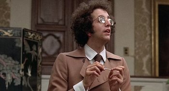 Movie still from “Taking Off” (1971), directed by Milos Forman – A man in a brown jacket and a tie; Close Up shot, Low angle