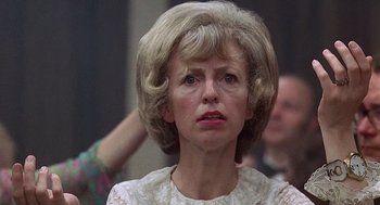 Movie still from “Taking Off” (1971), directed by Milos Forman – An older woman with a frowning look on her face; Close Up shot, Low angle