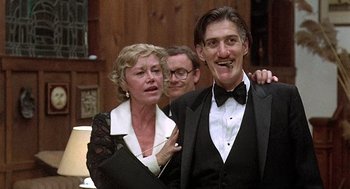 Movie still from “Taking Off” (1971), directed by Milos Forman – A man and a woman posing for a picture with another man; Medium shot, Low angle