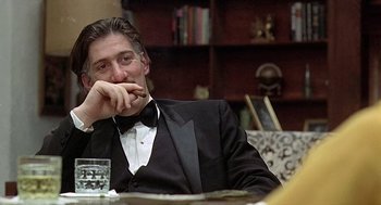 Movie still from “Taking Off” (1971), directed by Milos Forman – A man sitting at a table with a glass of water; Close Up shot, Low angle
