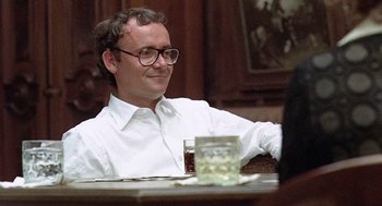 Movie still from “Taking Off” (1971), directed by Milos Forman – A man sitting at a table with a glass of water; Close Up shot, Over the shoulder angle