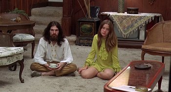 Movie still from “Taking Off” (1971), directed by Milos Forman – A man and a woman sitting on the ground; Medium shot, High angle