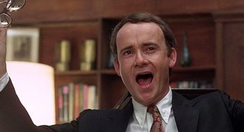 Movie still from “Taking Off” (1971), directed by Milos Forman – A man in a suit and tie with his mouth wide open; Close Up shot, Low angle