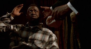 Movie still from “Tales from the Hood” (1995), directed by Rusty Cundieff – A man in a plaid shirt is surrounded by hands; Close Up shot, Low angle
