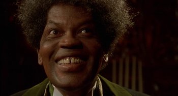 Movie still from “Tales from the Hood” (1995), directed by Rusty Cundieff – A person with a smile on their face; Close Up shot, Low angle