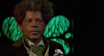 Movie still from “Tales from the Hood” (1995), directed by Rusty Cundieff – A person wearing a suit and tie; Close Up shot, Low angle