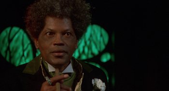 Movie still from “Tales from the Hood” (1995), directed by Rusty Cundieff – A person wearing a suit and tie; Close Up shot, Low angle