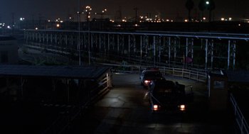 Movie still from “Tales from the Hood” (1995), directed by Rusty Cundieff – Cars parked on the side of a road at night; Extreme Wide shot, High angle