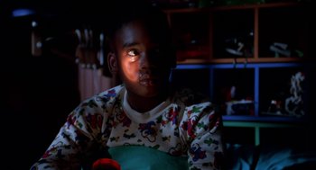 Movie still from “Tales from the Hood” (1995), directed by Rusty Cundieff – A young boy is sitting in the dark; Close Up shot, High angle
