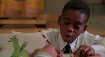 Movie still from “Tales from the Hood” (1995), directed by Rusty Cundieff – A boy in a white dress shirt and a black tie; Close Up shot, High angle