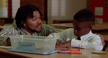 Movie still from “Tales from the Hood” (1995), directed by Rusty Cundieff – A man and a boy sitting at a table with crayons; Medium shot, Low angle