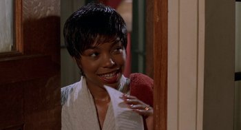 Movie still from “Tales from the Hood” (1995), directed by Rusty Cundieff – A woman holding a piece of paper in her hand; Close Up shot, Over the shoulder angle