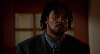 Movie still from “Tales from the Hood” (1995), directed by Rusty Cundieff – A person wearing a suit and tie; Close Up shot, Low angle