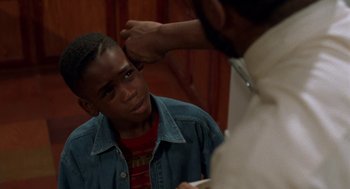 Movie still from “Tales from the Hood” (1995), directed by Rusty Cundieff – A young man getting his hair cut by a barber; Close Up shot, Over the shoulder angle