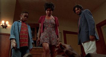 Movie still from “Tales from the Hood” (1995), directed by Rusty Cundieff – A group of people standing in a living room; Medium shot, Low angle