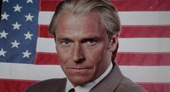 Movie still from “Tales from the Hood” (1995), directed by Rusty Cundieff – A man that is wearing a suit and tie; Close Up shot, Low angle