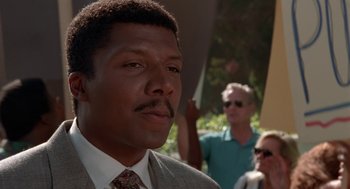 Movie still from “Tales from the Hood” (1995), directed by Rusty Cundieff – A man in a suit and tie looking at the camera; Close Up shot, Low angle
