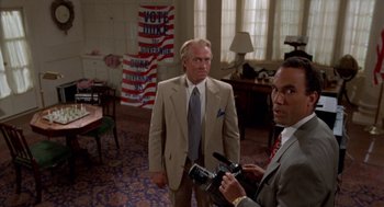 Movie still from “Tales from the Hood” (1995), directed by Rusty Cundieff – A man in a suit and tie standing next to another man in a suit and tie; Medium shot, High angle