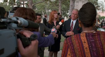 Movie still from “Tales from the Hood” (1995), directed by Rusty Cundieff – A group of people standing next to each other holding microphones; Medium shot, Over the shoulder angle