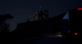 Movie still from “Tales from the Hood” (1995), directed by Rusty Cundieff – A night view of a castle on top of a hill; Extreme Wide shot, Low angle