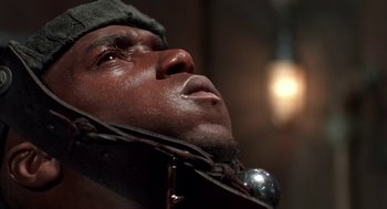 Movie still from “Tales from the Hood” (1995), directed by Rusty Cundieff – A person wearing a hat; Close Up shot, High angle