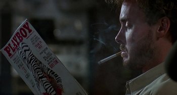 Movie still from “Talk Radio” (1988), directed by Oliver Stone – A person smoking a cigarette; Close Up shot, Low angle