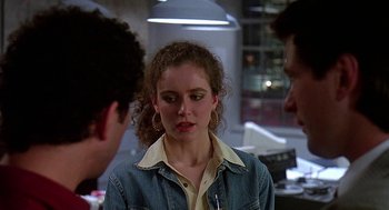 Movie still from “Talk Radio” (1988), directed by Oliver Stone – A woman in a jean jacket is talking to two men; Close Up shot, Over the shoulder angle