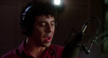 Movie still from “Talk Radio” (1988), directed by Oliver Stone – A man with a microphone in a recording studio; Close Up shot, Low angle