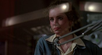 Movie still from “Talk Radio” (1988), directed by Oliver Stone – A young woman with large hoop earings looking at the camera; Close Up shot, Over the shoulder angle