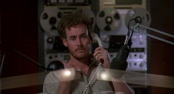 Movie still from “Talk Radio” (1988), directed by Oliver Stone – A man holding a phone up to his ear; Close Up shot, High angle