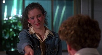 Movie still from “Talk Radio” (1988), directed by Oliver Stone – A woman in a jean jacket shaking a man's hand; Close Up shot, Over the shoulder angle