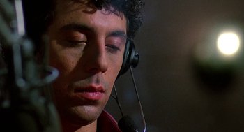Movie still from “Talk Radio” (1988), directed by Oliver Stone – A person wearing a headset; Close Up shot, Low angle