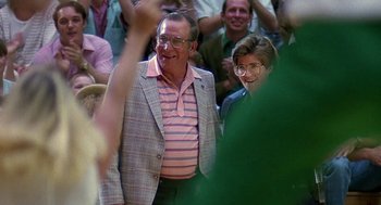 Movie still from “Talk Radio” (1988), directed by Oliver Stone – An older man wearing a pink striped shirt and a pink and white striped shirt; Medium shot, Low angle