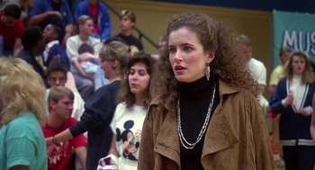 Movie still from “Talk Radio” (1988), directed by Oliver Stone – A group of people standing in front of a crowd of people; Medium shot, Over the shoulder angle