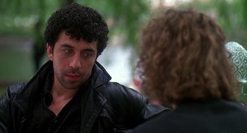 Movie still from “Talk Radio” (1988), directed by Oliver Stone – A man in a leather jacket talking to a woman; Close Up shot, Over the shoulder angle
