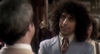 Movie still from “Talk Radio” (1988), directed by Oliver Stone – A man in a suit and tie talking to another man in a suit and tie; Close Up shot, Over the shoulder angle