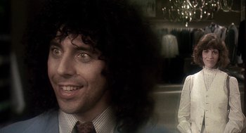 Movie still from “Talk Radio” (1988), directed by Oliver Stone – A person wearing a suit and tie; Close Up shot, Over the shoulder angle