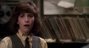 Movie still from “Talk Radio” (1988), directed by Oliver Stone – A woman in a yellow shirt and a black tie; Close Up shot, Over the shoulder angle