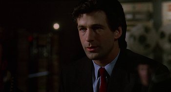Movie still from “Talk Radio” (1988), directed by Oliver Stone – A person wearing a suit and tie; Close Up shot, Low angle