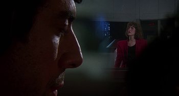 Movie still from “Talk Radio” (1988), directed by Oliver Stone – A man and a woman looking at one another; Extreme Close Up shot, Low angle