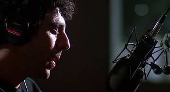 Movie still from “Talk Radio” (1988), directed by Oliver Stone – A person with a microphone; Close Up shot, Low angle