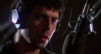 Movie still from “Talk Radio” (1988), directed by Oliver Stone – A person wearing headphones and a microphone; Close Up shot, Low angle