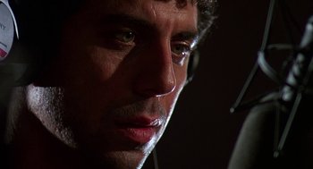Movie still from “Talk Radio” (1988), directed by Oliver Stone – A man's face in the dark; Extreme Close Up shot, Low angle