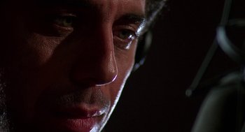 Movie still from “Talk Radio” (1988), directed by Oliver Stone – A man's face in the dark; Extreme Close Up shot, Low angle